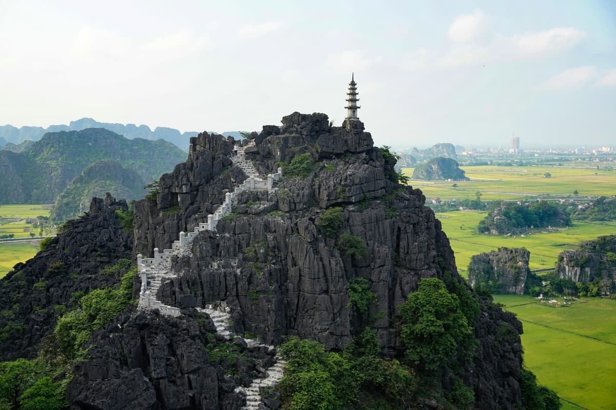 L’escalier de pierre et la pagode de Hang Mua au-dessus des rizières de Ninh Binh
