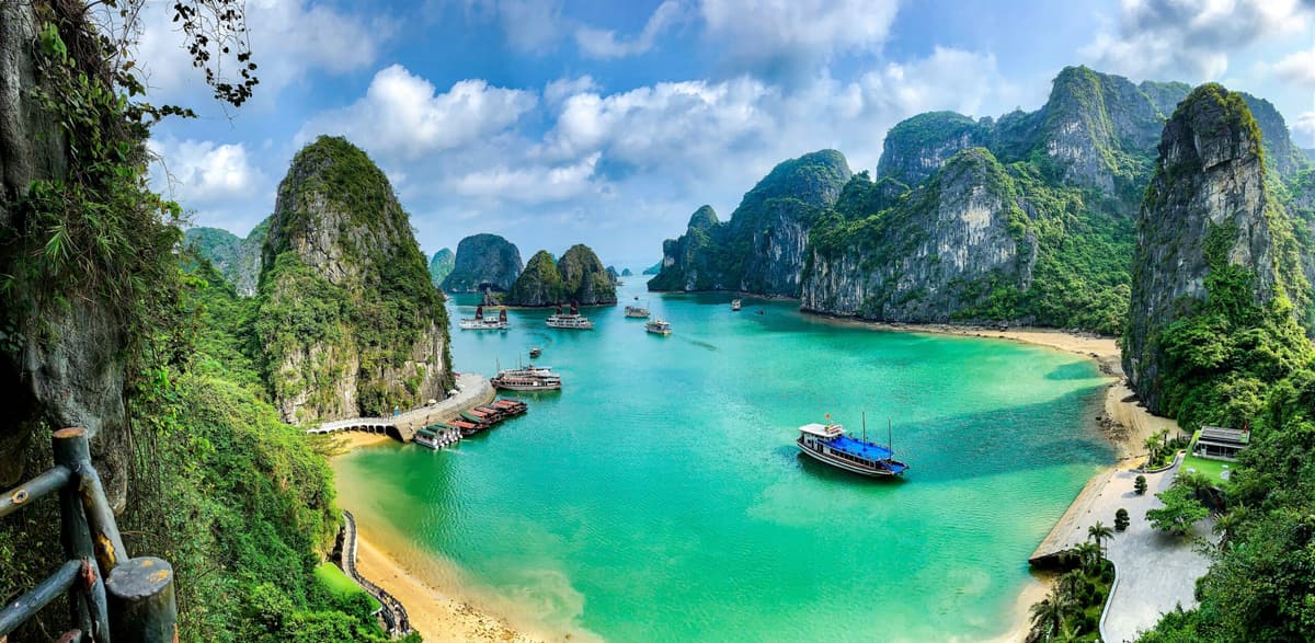 Eau émeraude et plage abritée parmi les pitons karstiques du nord du Vietnam