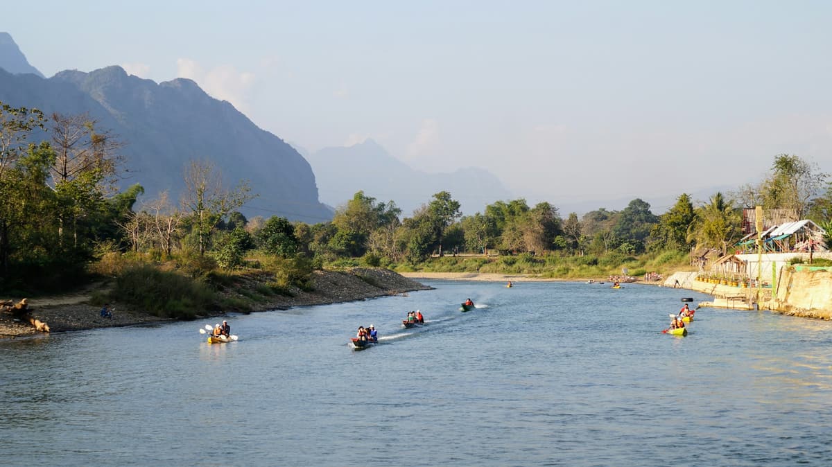 El río Nam Song en Vang Vieng, al pie de los picos calizos, surcado por kayaks y barcas