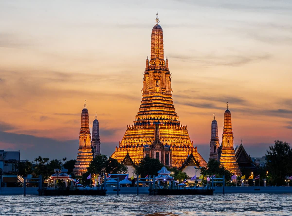 Le Wat Arun illuminé au crépuscule, au bord de la Chao Phraya, Bangkok